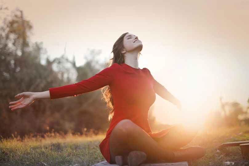 woman wearing red dress while sitting on grass